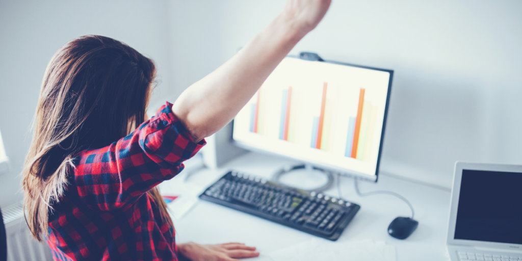 Grant seeker celebrating grant management drawdown tips at her desk