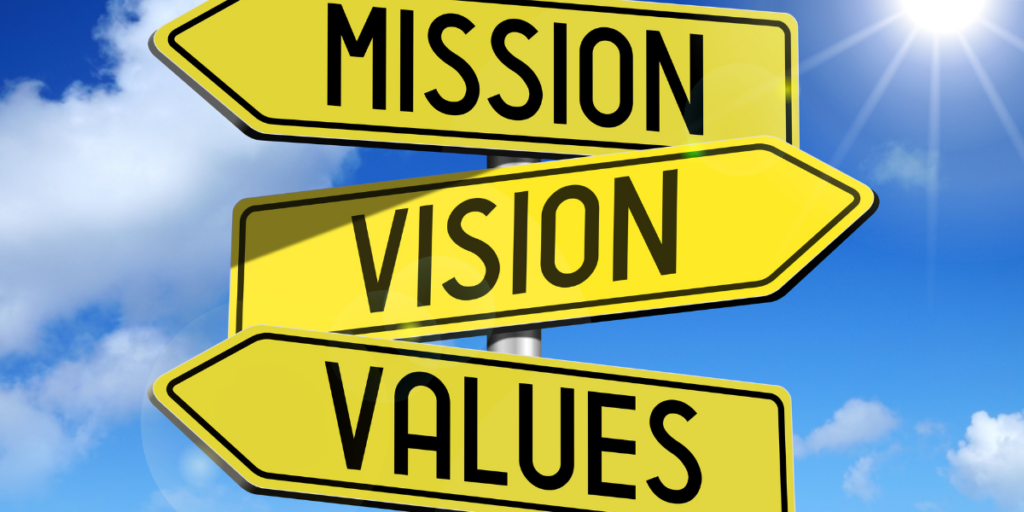 Mission, vision, values, written on yellow signs to help turn grants team into a mission driven staff.