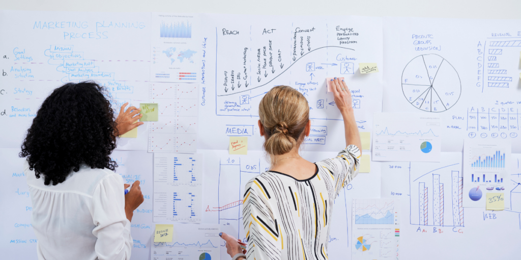 Grant managers writing on a board to centralize their grant management process with limited resources