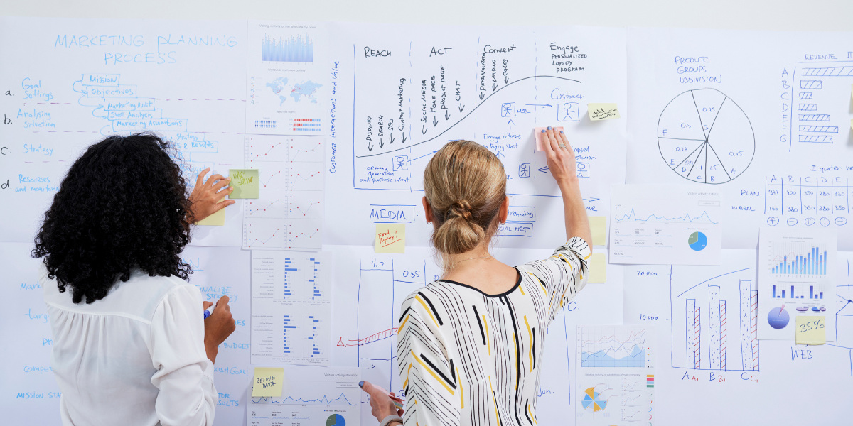 Grant managers writing on a board to centralize their grant management process with limited resources