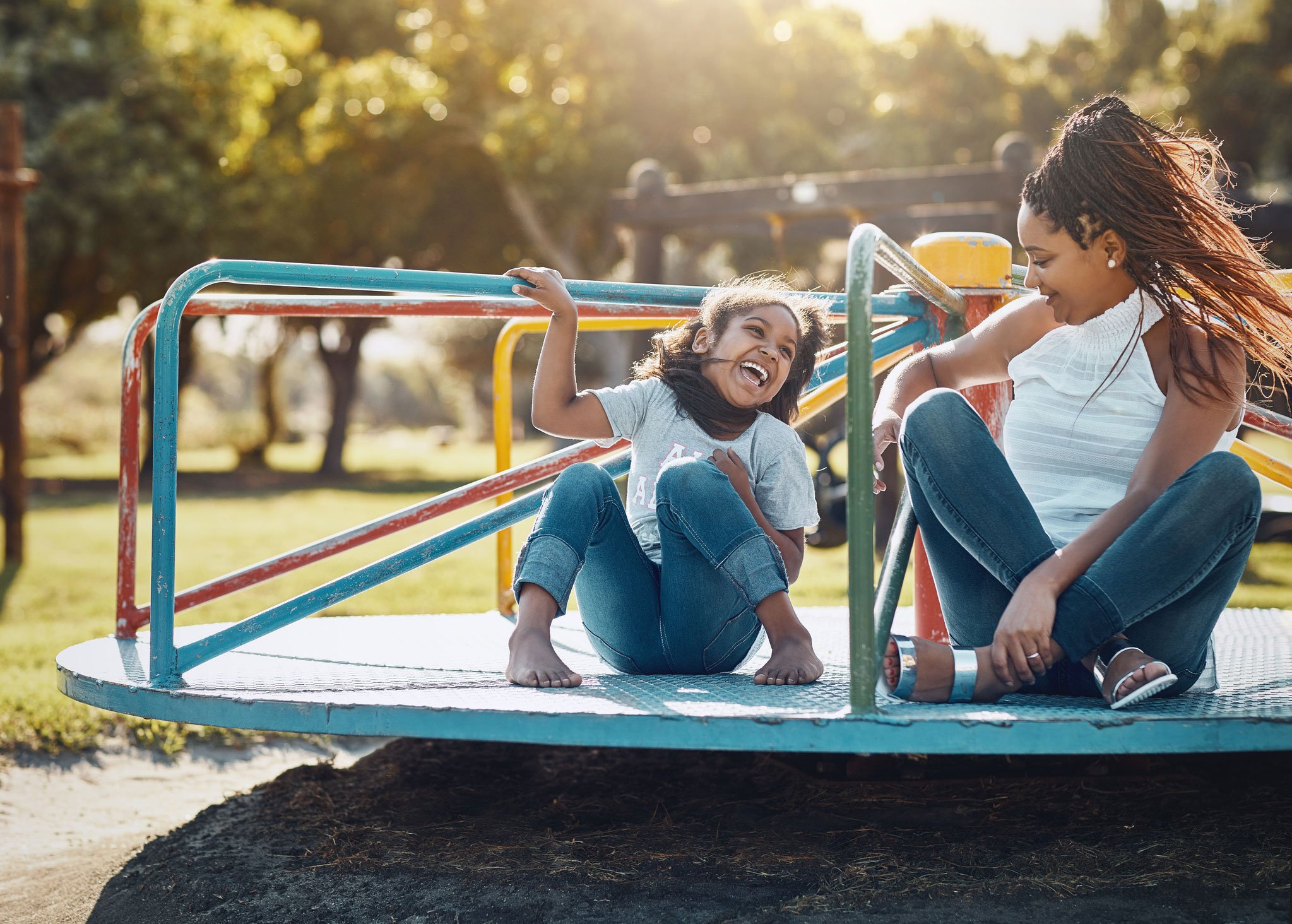 Mother and daughter on playground spinner